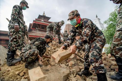 Picture of Nepalese security forces excavating ancient carvings and artifacts in Nepal Nepalese troops look for bodies at Patan Durbar Square. Looting at damaged and destroyed shrines and temples has been minimal, according to UNESCO officials. Bulldozers used to clear debris are a bigger threat.  PHOTOGRAPH BY BRIAN SOKOL, PANOS 
